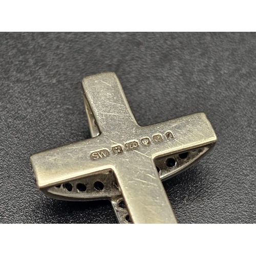 121 - An 18 K white gold, sapphire set, cross. Fully hallmarked, with maker's mark SW, believed to be an e... 