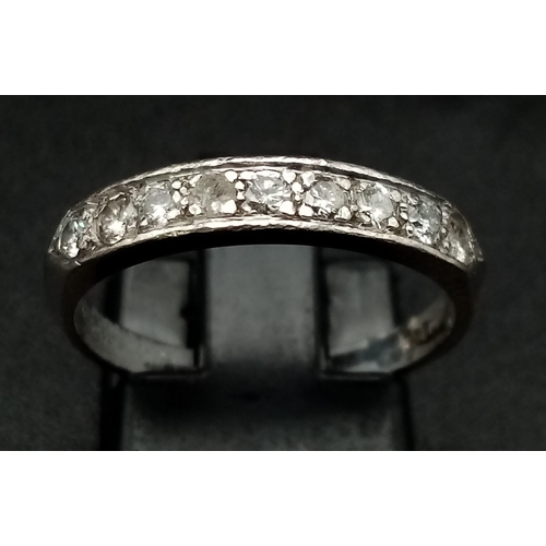 265 - An 18 K white gold ring with a band of nine diamonds (0.30 carats). Ring size: N1/2, weight: 2.9 g.