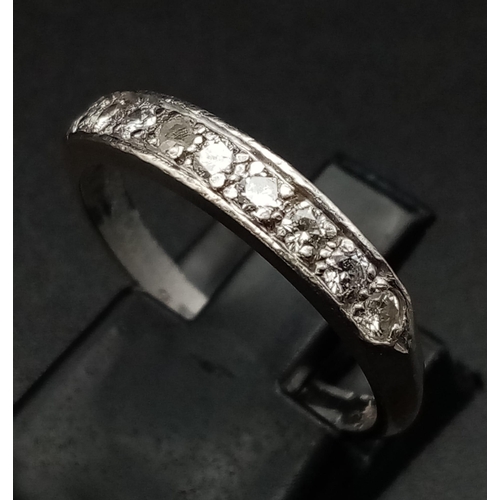 265 - An 18 K white gold ring with a band of nine diamonds (0.30 carats). Ring size: N1/2, weight: 2.9 g.