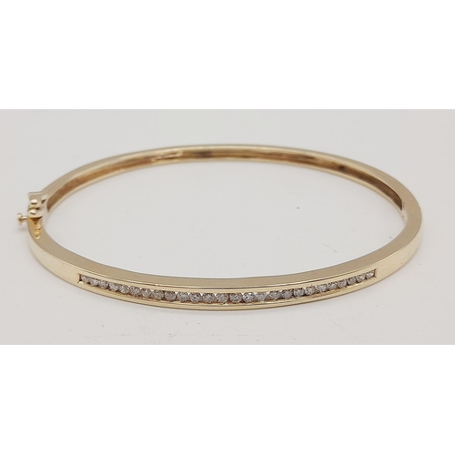 48 - 9K YELLOW GOLD DIAMOND SET BANGLE. 0.60CT DIAMOND. TOTAL WEIGHT 10.1G