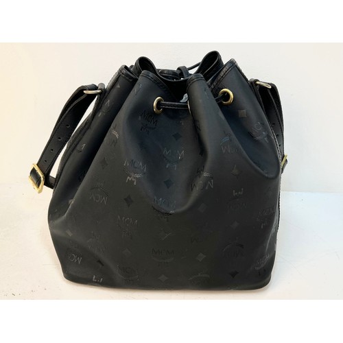 116 - A MCM Black Leather Bucket Monogram Canvas Shoulder Bag. Leather draw string top. Gold tone hardware... 