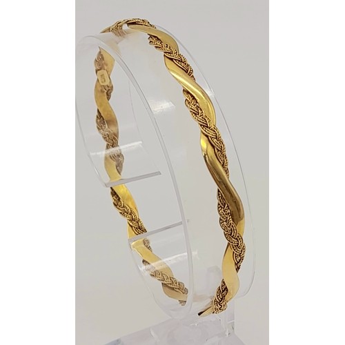 9 - A Vintage 18K Yellow Gold Twist Bangle. An overlapping wave design creates a stylish piece. 6.5cm in... 