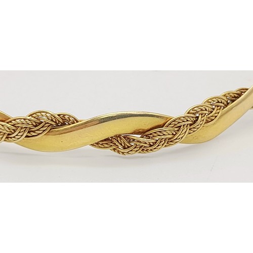 9 - A Vintage 18K Yellow Gold Twist Bangle. An overlapping wave design creates a stylish piece. 6.5cm in... 