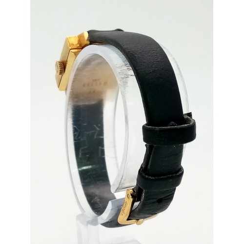 137 - A Vintage Nisus 18K Gold Ladies Watch. Black leather strap. Square 18K gold case with bark-effect de... 