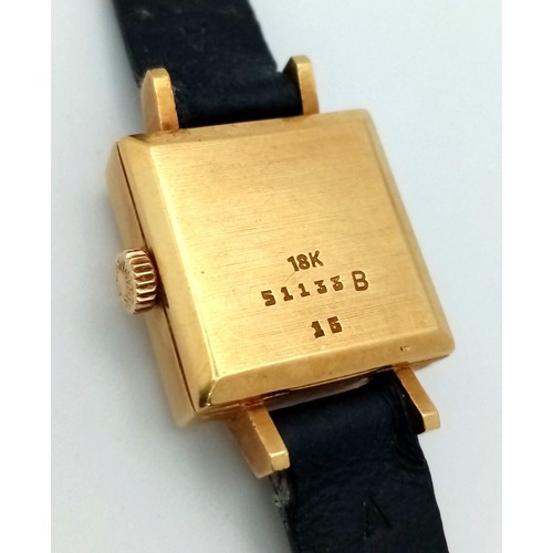 137 - A Vintage Nisus 18K Gold Ladies Watch. Black leather strap. Square 18K gold case with bark-effect de... 