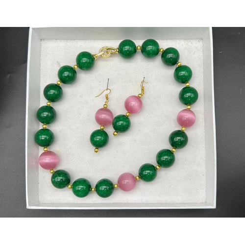 133 - A statement necklace and earrings set with large (20 mm) green spinach jade and pink cat’s eyes. In ... 