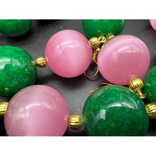 133 - A statement necklace and earrings set with large (20 mm) green spinach jade and pink cat’s eyes. In ... 