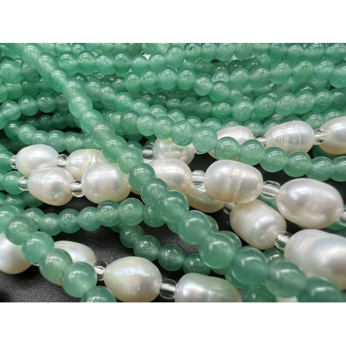 147 - A very feminine, Belle Epoque reminiscent necklace. Three long strands (130 cm) of pale green jade a... 