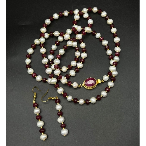 231 - A very elegant, opera length necklace and earrings set with natural white pearls and faceted rubies,... 