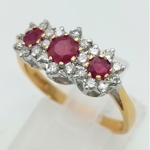 303 - An 18K Yellow Gold Ruby and Diamond Ring. Three rubies all with a halo of diamonds. UK Hallmarks. Si... 