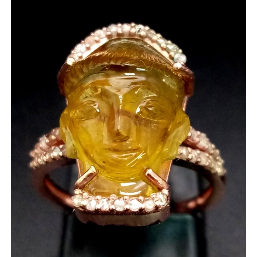 91 - A 14K Rose Gold 9.6ct Tourmaline Ring in the Carved Shape of a Buddha. Size L. Comes with an AIG Mil... 