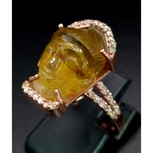 91 - A 14K Rose Gold 9.6ct Tourmaline Ring in the Carved Shape of a Buddha. Size L. Comes with an AIG Mil... 