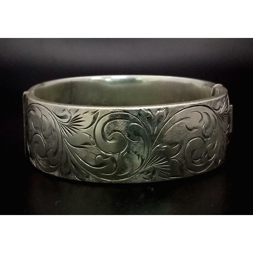 349 - A 925 Silver Vintage Bangle. Clip opening extender. Floral engraved decoration. 6cm inner diameter. ... 