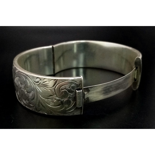 349 - A 925 Silver Vintage Bangle. Clip opening extender. Floral engraved decoration. 6cm inner diameter. ... 