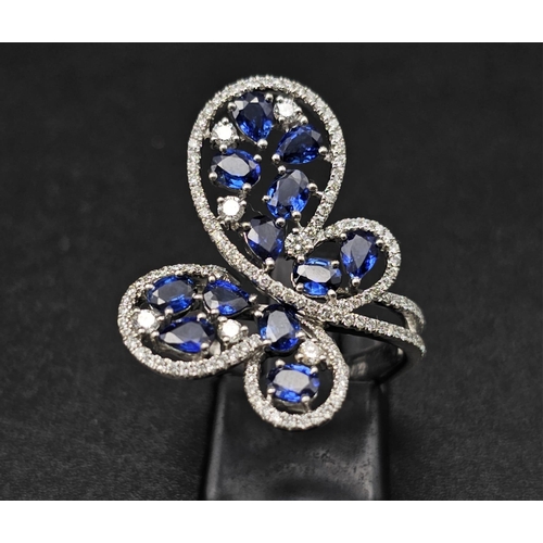 167 - A glamorous 18 K white gold ring with numerous blue sapphires and diamonds. Ring size: N, weight: 7.... 