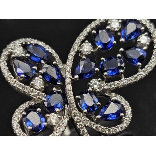 167 - A glamorous 18 K white gold ring with numerous blue sapphires and diamonds. Ring size: N, weight: 7.... 