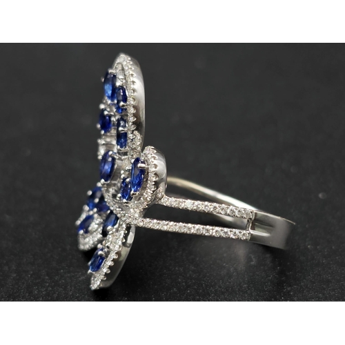 167 - A glamorous 18 K white gold ring with numerous blue sapphires and diamonds. Ring size: N, weight: 7.... 