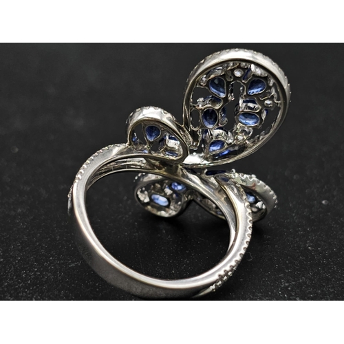 167 - A glamorous 18 K white gold ring with numerous blue sapphires and diamonds. Ring size: N, weight: 7.... 