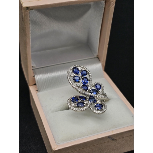 167 - A glamorous 18 K white gold ring with numerous blue sapphires and diamonds. Ring size: N, weight: 7.... 