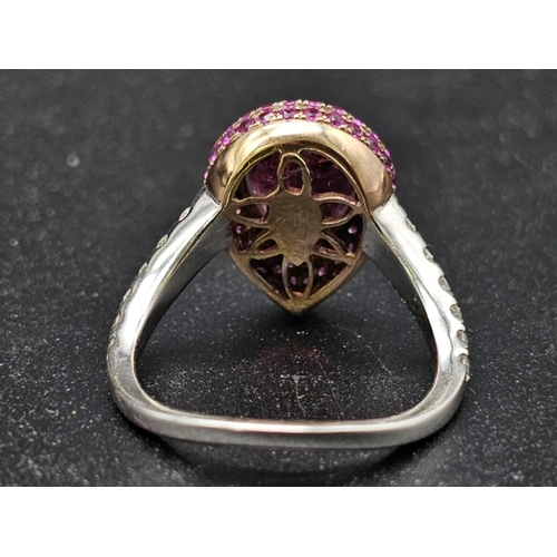 174 - An extraordinary 18 K white gold ring with a central pear cut rubelite  (3 carats appr), surrounded ... 