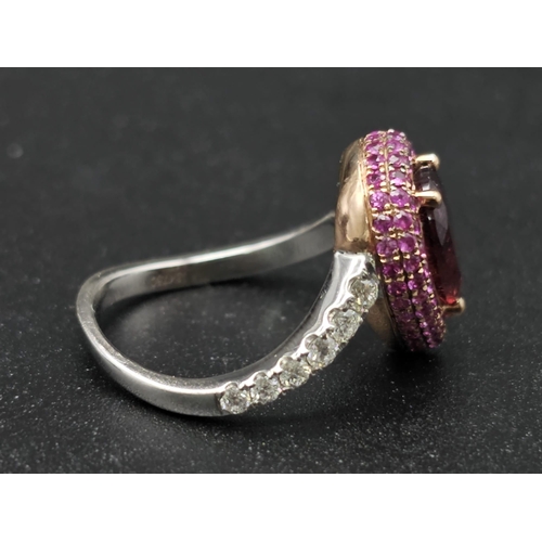 174 - An extraordinary 18 K white gold ring with a central pear cut rubelite  (3 carats appr), surrounded ... 