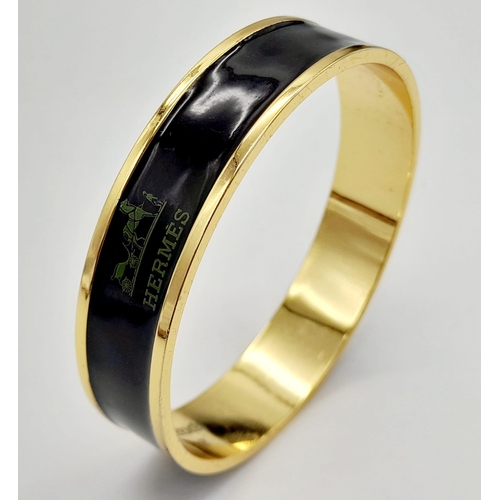 325 - A Hermes Gold Plated Bangle. Logo on inner and outer black enamel. 6.5cm inner diameter.