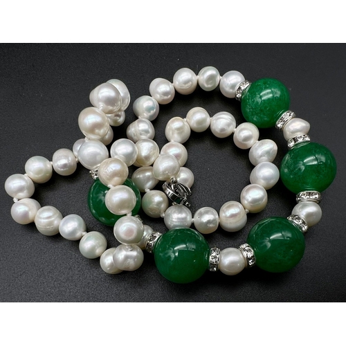 697 - A Cultured Pearl and Green Jade Necklace. 14mm jade beads.
Necklace length - 42cm