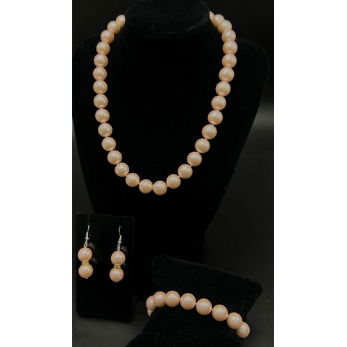 725 - A Pink Pearl Shell Necklace, Bracelet and Earring Set. 14mm pink pearl shells. Gilded clasps on brac... 