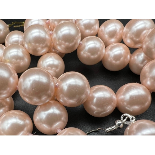 725 - A Pink Pearl Shell Necklace, Bracelet and Earring Set. 14mm pink pearl shells. Gilded clasps on brac... 