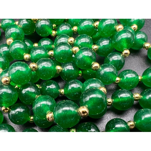 1045 - A Two-Row Jade Bead Necklace with Gilded Spacers and Clasp. 42cm. Jade beads - 8mm.