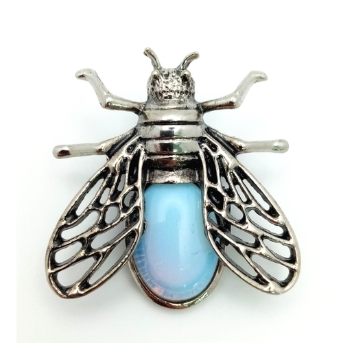 1371 - An Opalite Bee Brooch. Set in white metal. Wingspan - 3.5cm