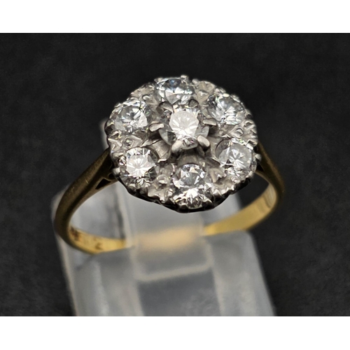 289 - An 18K Yellow Gold and Platinum Diamond Ring. Seven near white diamonds create the perfect flower. 1... 