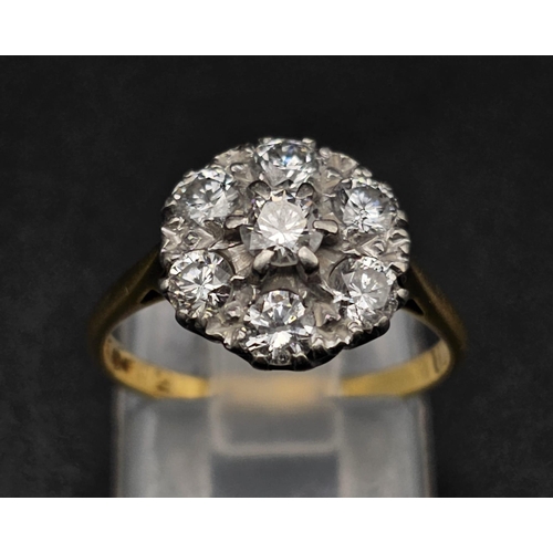 289 - An 18K Yellow Gold and Platinum Diamond Ring. Seven near white diamonds create the perfect flower. 1... 