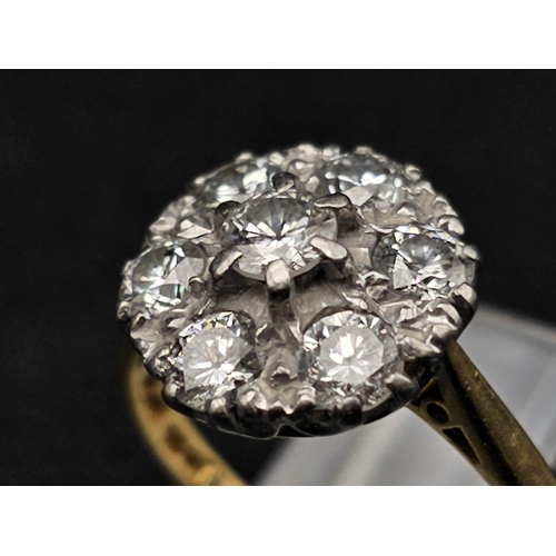 289 - An 18K Yellow Gold and Platinum Diamond Ring. Seven near white diamonds create the perfect flower. 1... 