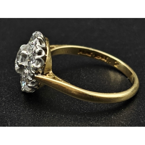 289 - An 18K Yellow Gold and Platinum Diamond Ring. Seven near white diamonds create the perfect flower. 1... 