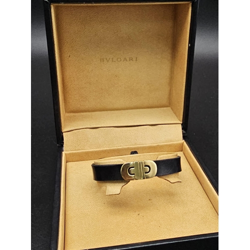 101 - A Bulgari Perentesi 18K Gold and Black Leather Bracelet. Comes in a Bulgari presentation case (worn ... 