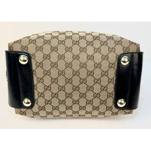 984 - A Gucci Abbey Handbag. Monogram beige cotton exterior with black leather trim. Gucci logo black disc... 