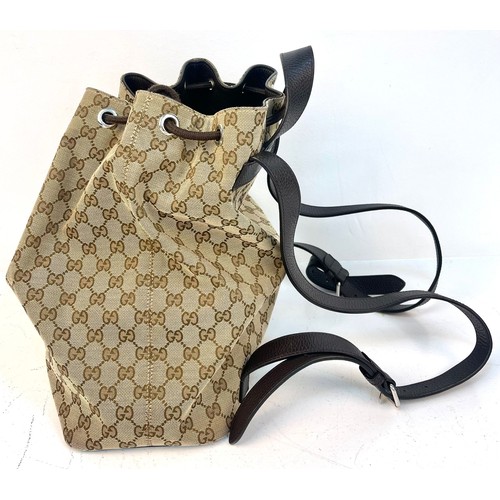 1086 - A Gucci Monogram Canvas Backpack with Dustcover. Brown leather shoulder straps and drawstring. Brown... 