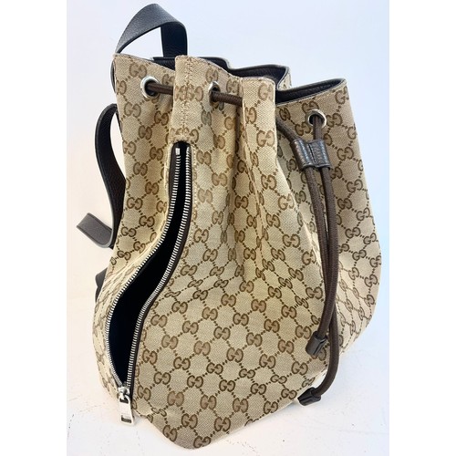 1086 - A Gucci Monogram Canvas Backpack with Dustcover. Brown leather shoulder straps and drawstring. Brown... 