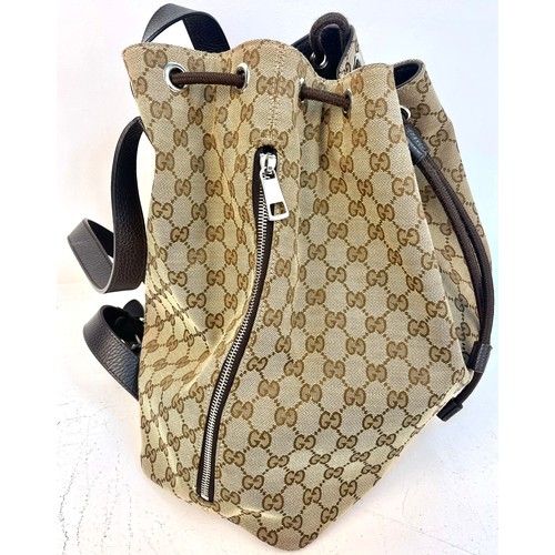 1086 - A Gucci Monogram Canvas Backpack with Dustcover. Brown leather shoulder straps and drawstring. Brown... 