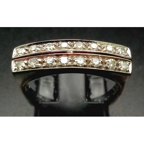 1136 - An 18 K white gold ring with two bands of white sapphires. Ring size: O, weight: 4.6 g.