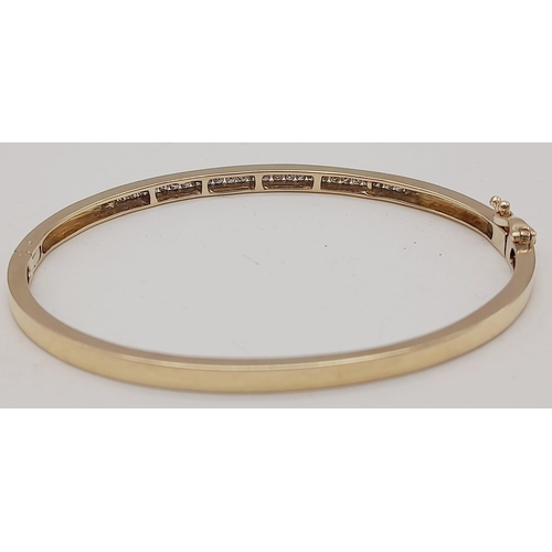 1094 - 9K YELLOW GOLD DIAMOND SET BANGLE. 0.60CT DIAMOND. TOTAL WEIGHT 10.1G