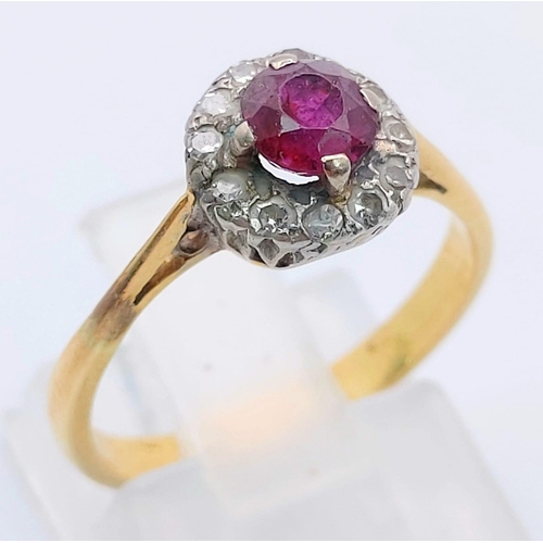 236 - An 18 K yellow gold ring with a round cut ruby surrounded by a halo of diamonds. Ring size: K, weigh... 