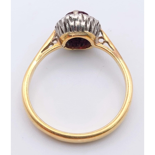 236 - An 18 K yellow gold ring with a round cut ruby surrounded by a halo of diamonds. Ring size: K, weigh... 