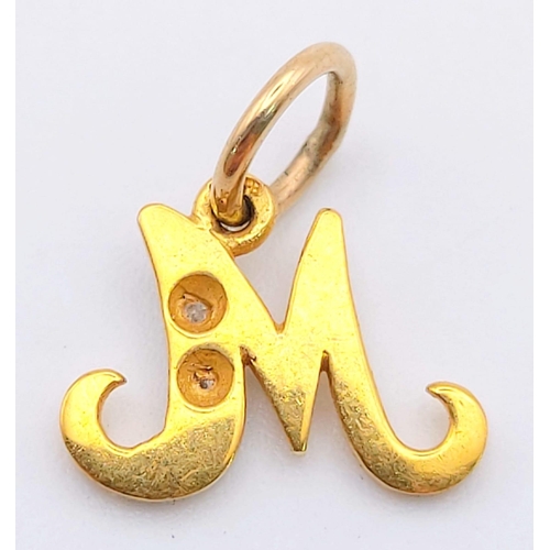 603 - A 14 K yellow gold diamond set pendant in the shape of the letter M. weight: 0.7 g.