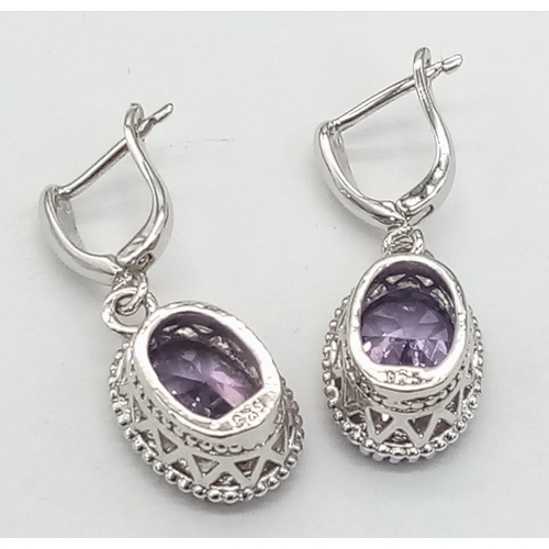 912 - A New Pair of Sterling Silver Crown Mounted Amethyst Set Secure Stud Earrings. Set with 14mm Oval Cu... 