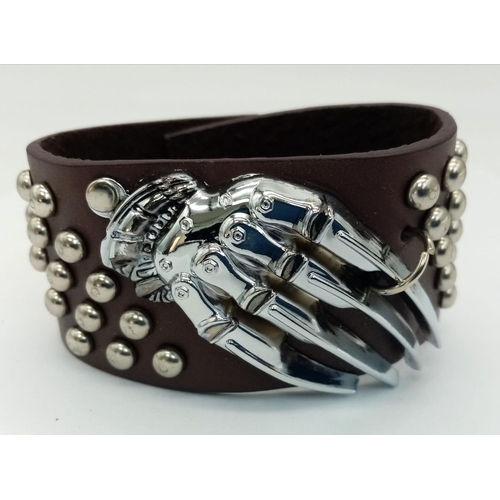 978 - A SKULL WATCH ON A BLACK LEATHER MILITARY STYLE STRAP, AND A SKELETON HAND LEATHER STUDDED BRACELET.... 