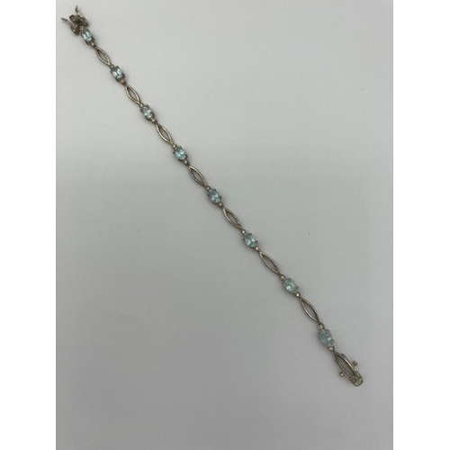 490 - BLUE TOPAZ and SILVER TENNIS BRACELET Having boat shaped silver links with 8  oval cut TOPAZ GEMSTON... 