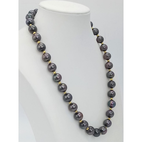 1195 - A Cultured Black Pearl Necklace. Gilded spacers and clasp. 42cm.