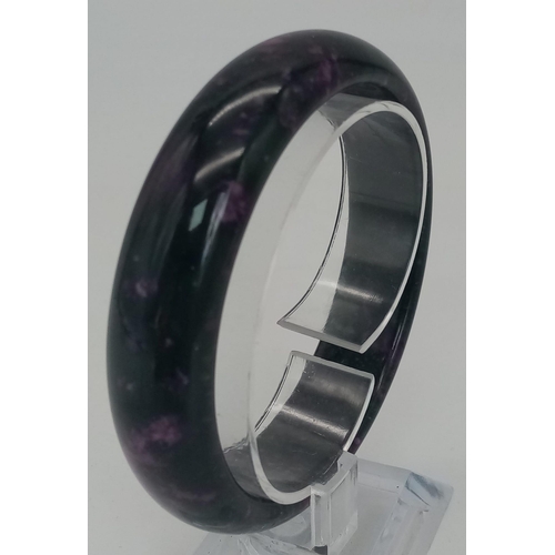 1080 - A Black and Pink Chinese Jade Bangle. 6cm inner diameter. 2cm width.